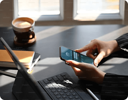 Person using mobile banking on a smartphone at a desk